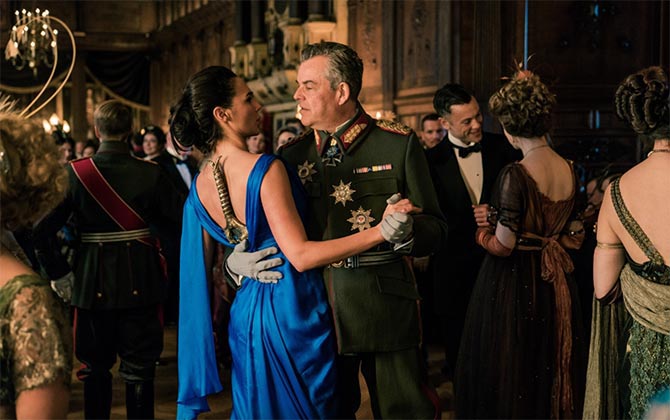 The only scene in 'Wonder Woman' when Diana (Gal Gadot) is not wearing her bracelets. She has her sword down her back while she dances with the enemy Ludendorff (Danny Houston). Photo Warner Brothers