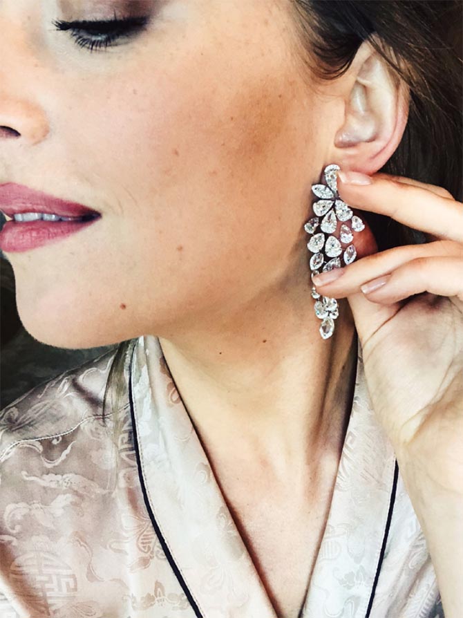 Dakota Johnson trying on the Nirav Modi diamond earrings she wore to the Golden Globes. Photo @kateyoung/Instagram stories