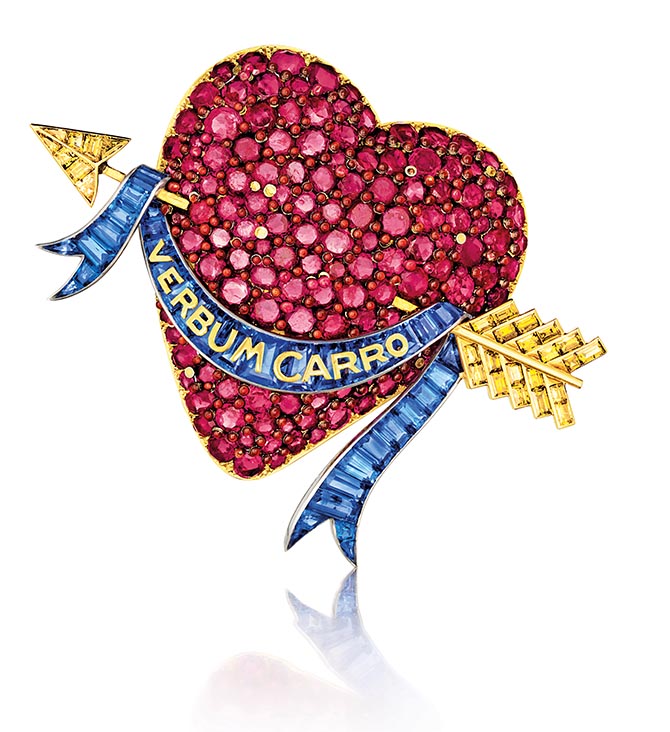 From Ruby: Heart brooch, Verdura for Paul Flato, Rubies set in a gold heart, colored diamonds and calibré-cut sapphires in a ribbon with the phrase “Verbum carro” meaning “The word made flesh” or “A word to my dear one.” Courtesy of Verdura