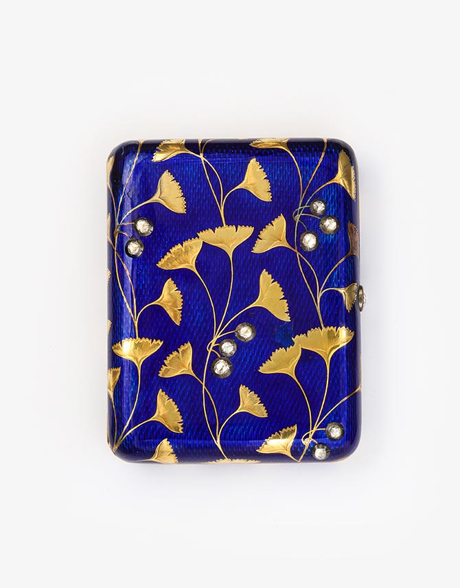 Fabergé Cigarette Case c. 1910 Gold, enamel, rose diamonds L 92 mm The Art Nouveau decoration of this gold and royal blue enamel cigarette case has an Egyptian-inspired design of gold gingko leaves with rose diamond buds. 