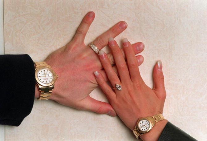 Posh and Becks modeled their rings and matching Rolexes for photographers when they announced their engagement. Photo Getty