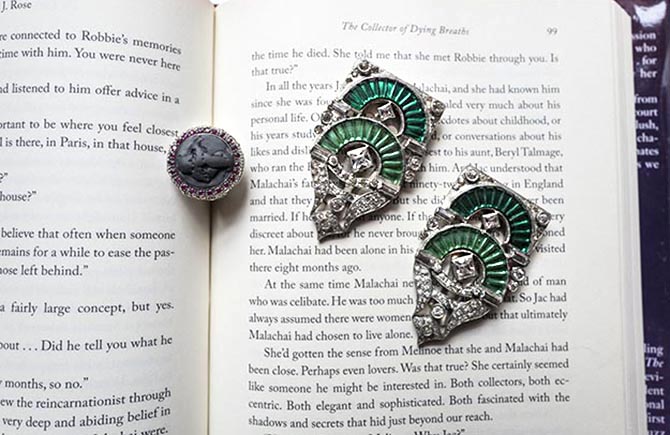 M.J. Rose's costume Art Deco clips and Amedo volcanic ash and ruby ring on top of a copy of her book 'The Collector of Dying Breaths.' Photo Sally Davies