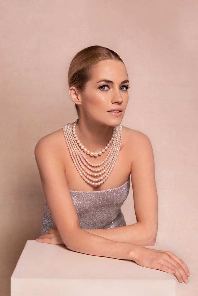 Amanda Hearst wearing a single strand natural pearl and diamond by Cartier and a five strand natural pearl and diamond necklace by Bhagat from the Maharajas & Mughal Magnificence auction in photo by Claiborne Swanson Frank for Christie’s.