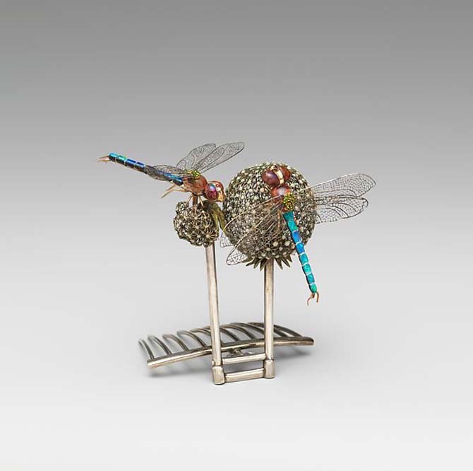 Tiffany & Co. hairpiece with dragonflies alighting on dandelion designed by Julia Munson under the direction of Louis Comfort Tiffany. The jewel is composed of Gold, silver, platinum, black opals, boulder opals, demantoid garnets, rubies, enamel. Photo Met