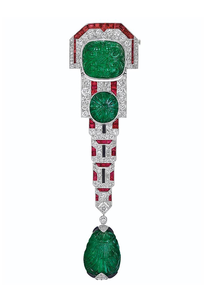 A MAGNIFICENT ART DECO CARVED EMERALD, DIAMOND, RUBY AND ONYX BROOCH, CHAUMET Cushion, oval and drop-shaped cabochon carved emeralds, calibré-cut rubies, old, single and rose-cut diamonds, cabochon onyx plaques, platinum and 18k white gold (French marks), 5 ¼ ins., circa 1925, signed Chaumet et Cie, 'Made in France' Provenance Lillian S. Timken